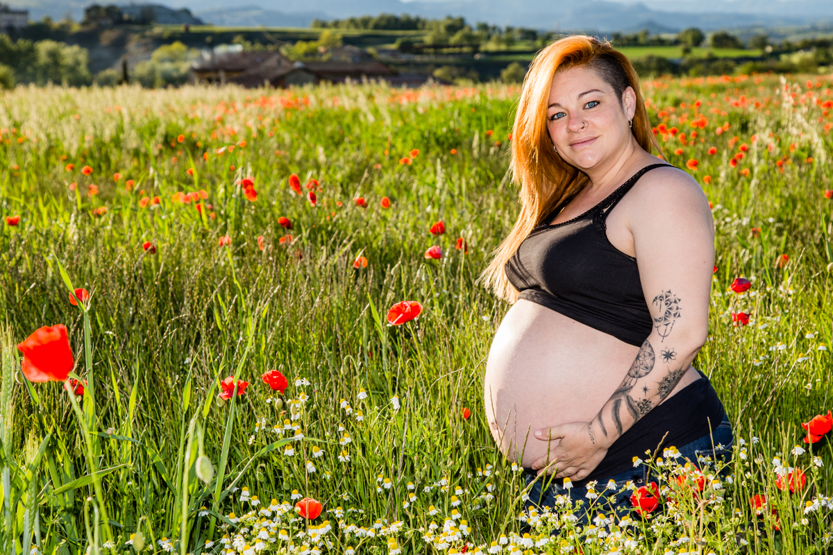 Fotografia noia embarassada en un camp de gallarets